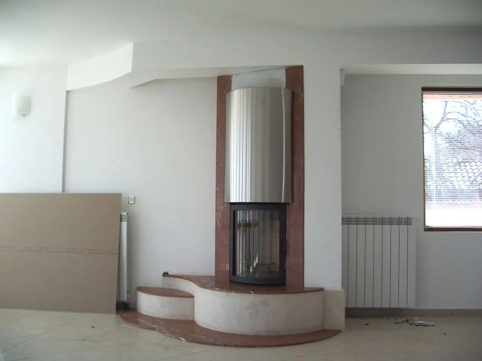 Овална камина 15 kW с мраморна облицовка и Врачански камък върху извит подиум